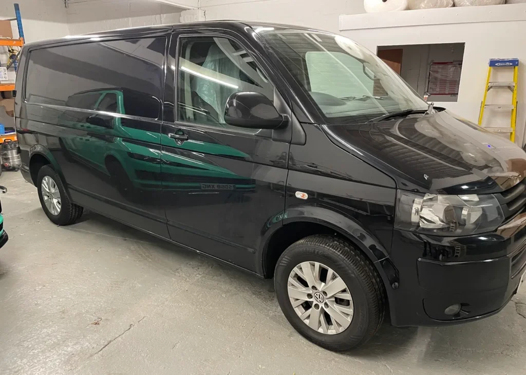 Side view of a black camper van indoors, designed as part of custom camper conversion projects in Manchester