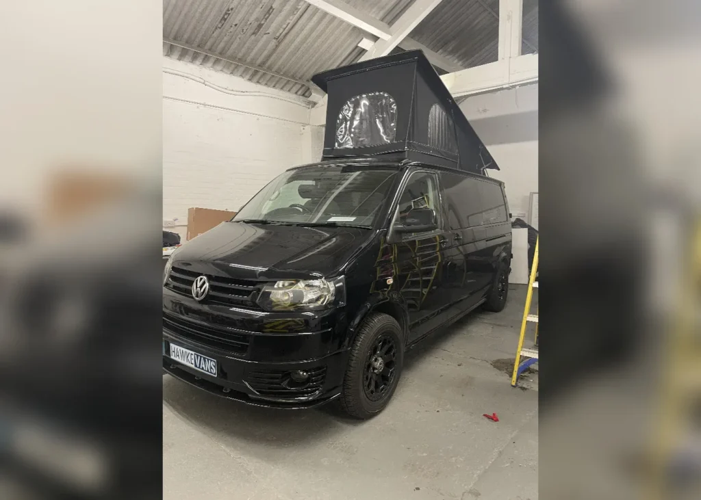 Black Volkswagen camper van with a pop-up roof, tailored for versatility and custom camper conversion in Manchester