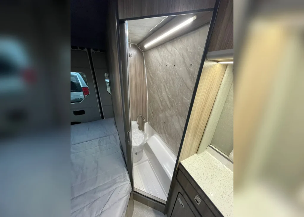 Camper van bathroom interior with a shower and compact sink, designed for practicality and style