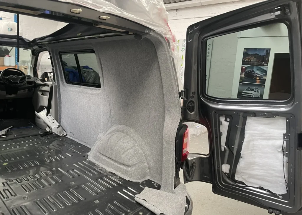 Interior of a grey camper van under construction, showcasing work in progress during a camper conversion in Manchester.