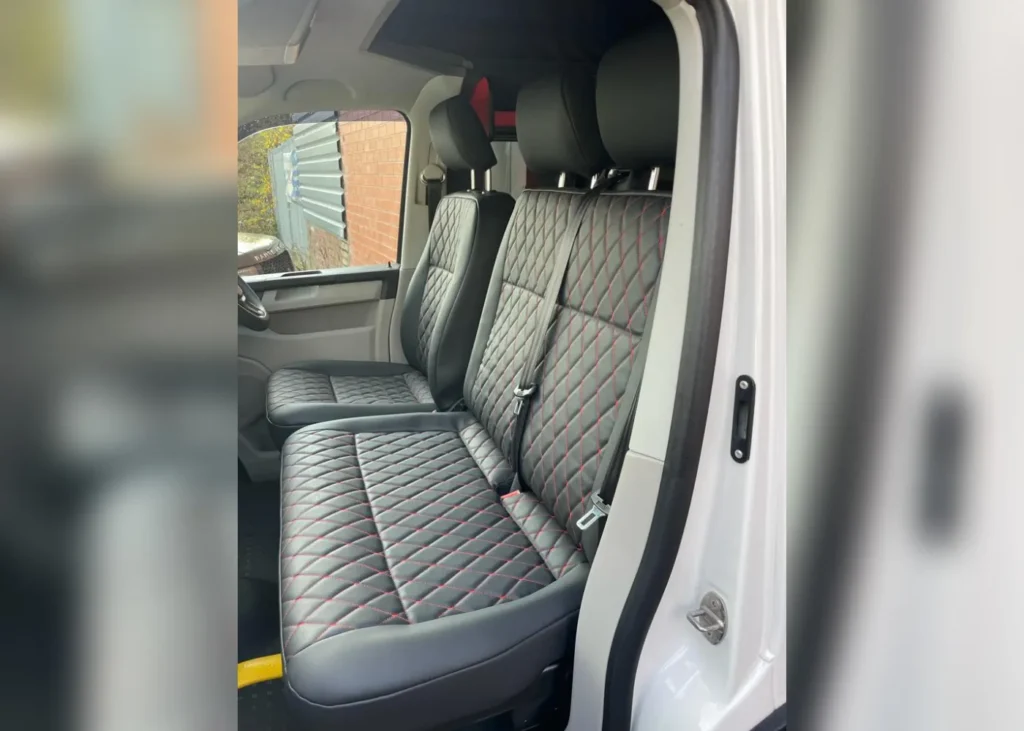 Camper van front leather seats with diamond stitching and red accents