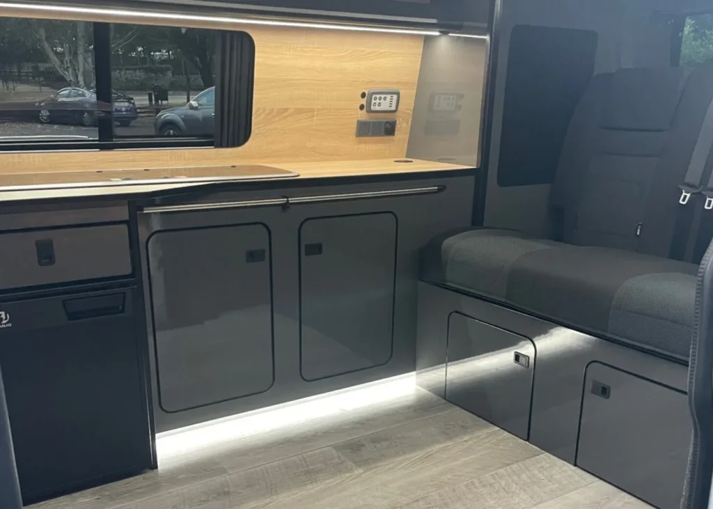 Modern camper kitchen with seating and storage area