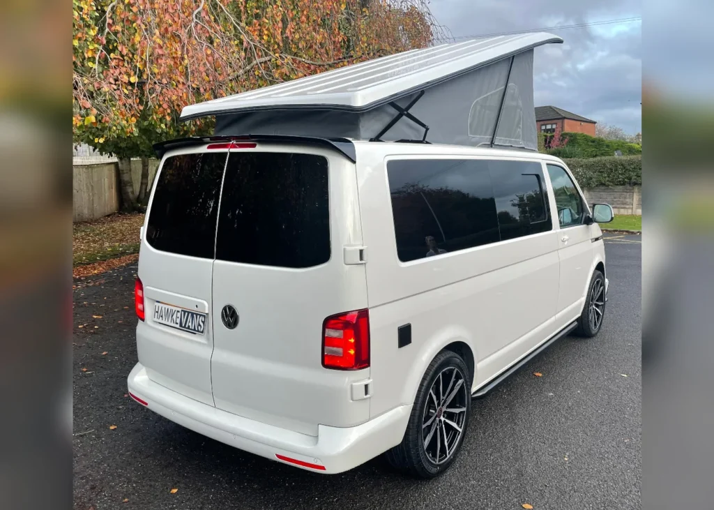 White camper van with raised roof and tinted windows, rear view