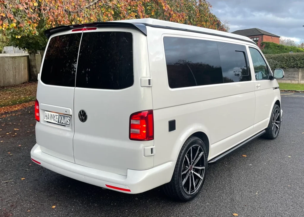 Custom white camper van rear view with tinted windows and alloy wheels