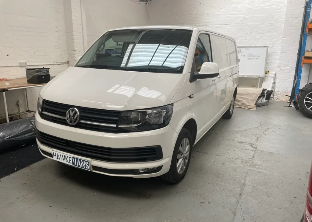 White camper van front view in a workshop