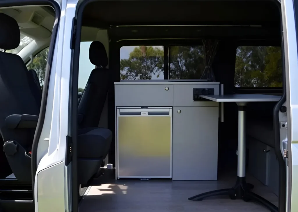 Camper van interior with fridge and table