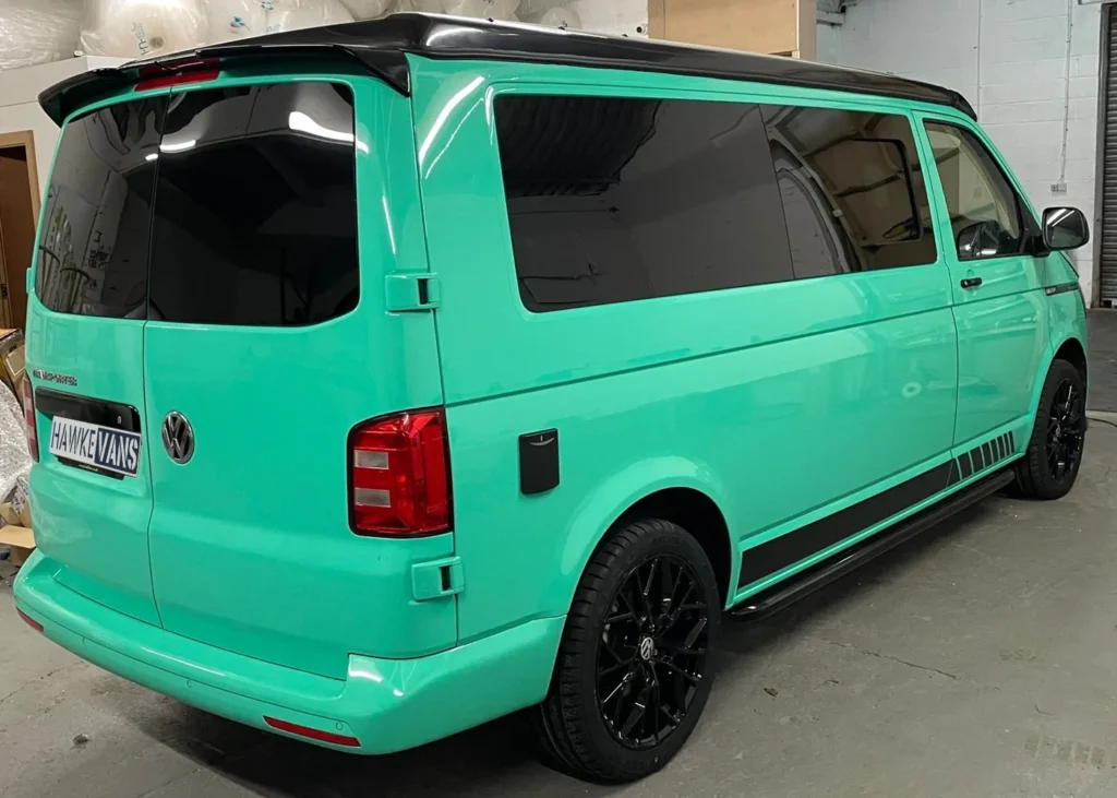 Mint green camper van with black accents and tinted windows