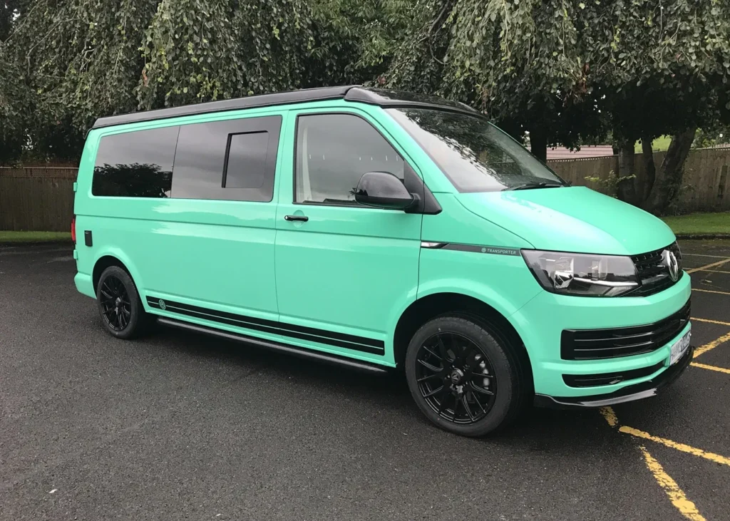 Mint green VW camper van with black detailing parked outdoors