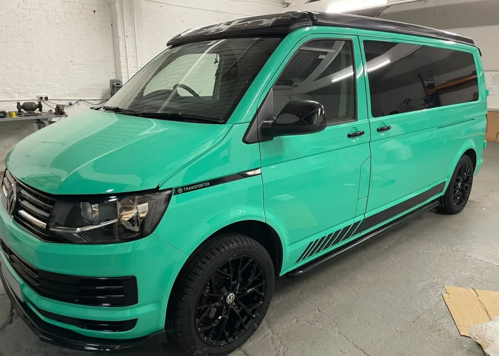 Mint green camper van front view with black accents