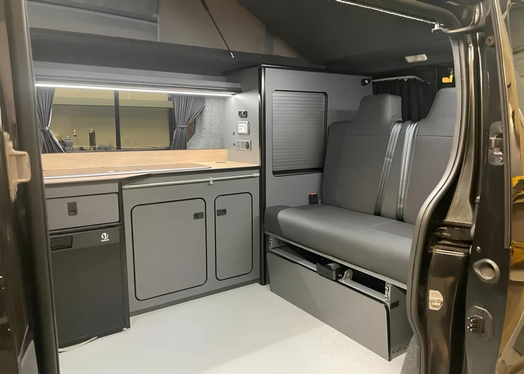 Modern camper van interior with kitchen and seating