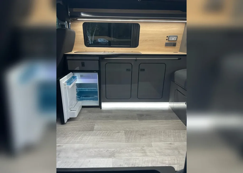 Modern camper kitchen with fridge and storage