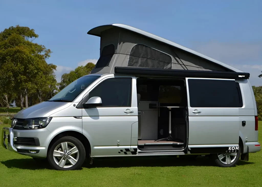 Silver camper van with pop-up roof and open sliding door