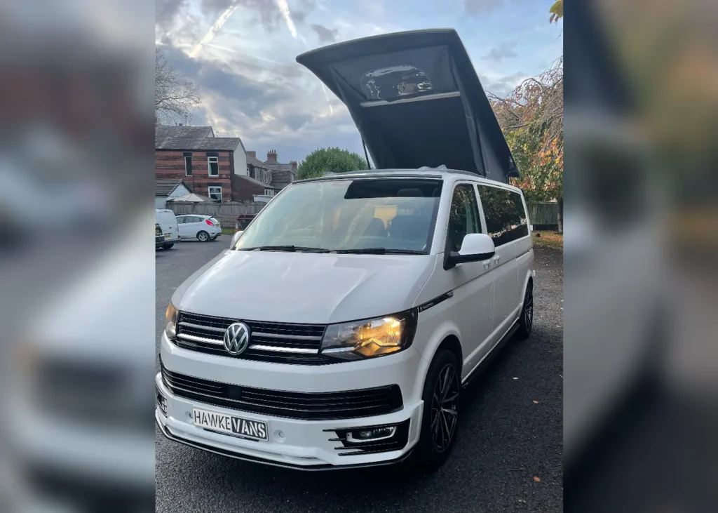 White Volkswagen camper van featuring a raised roof for additional space