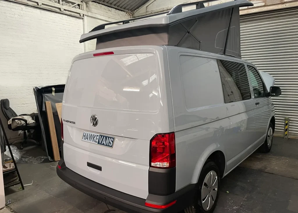 White camper van with raised roof in workshop